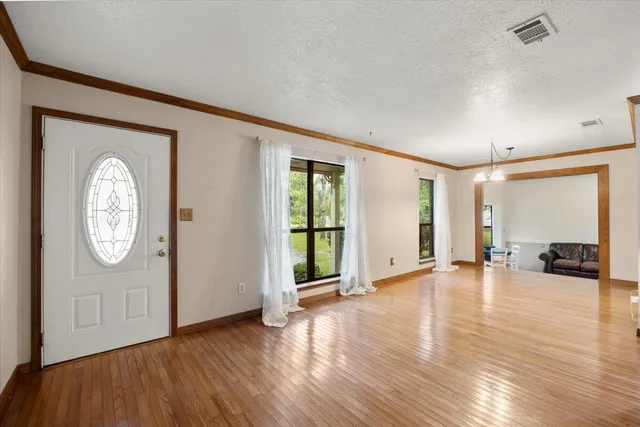 an empty room with window and wooden floor