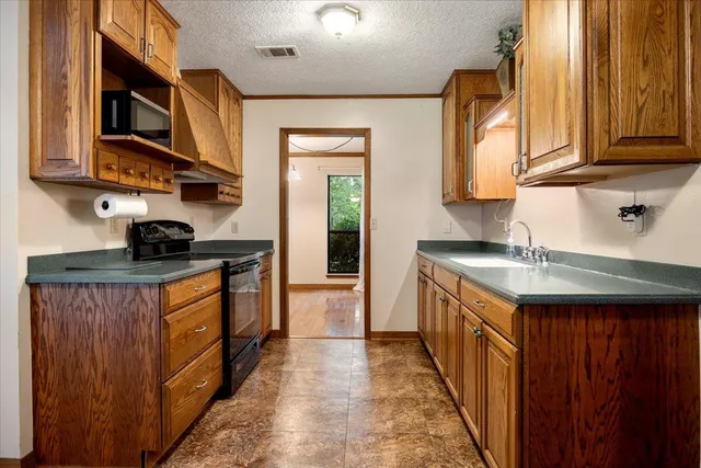 a kitchen with stainless steel appliances granite countertop a sink stove and microwave