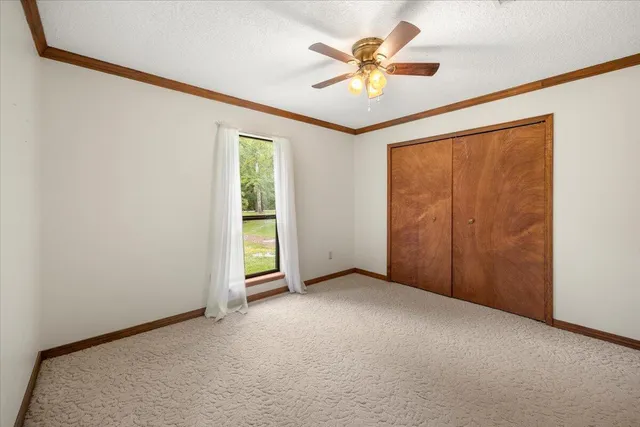 an empty room with a window and a ceiling fan