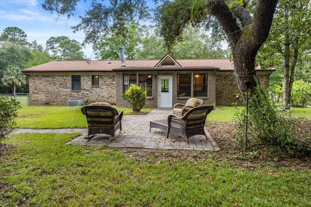 a view of a house with backyard sitting area and garden