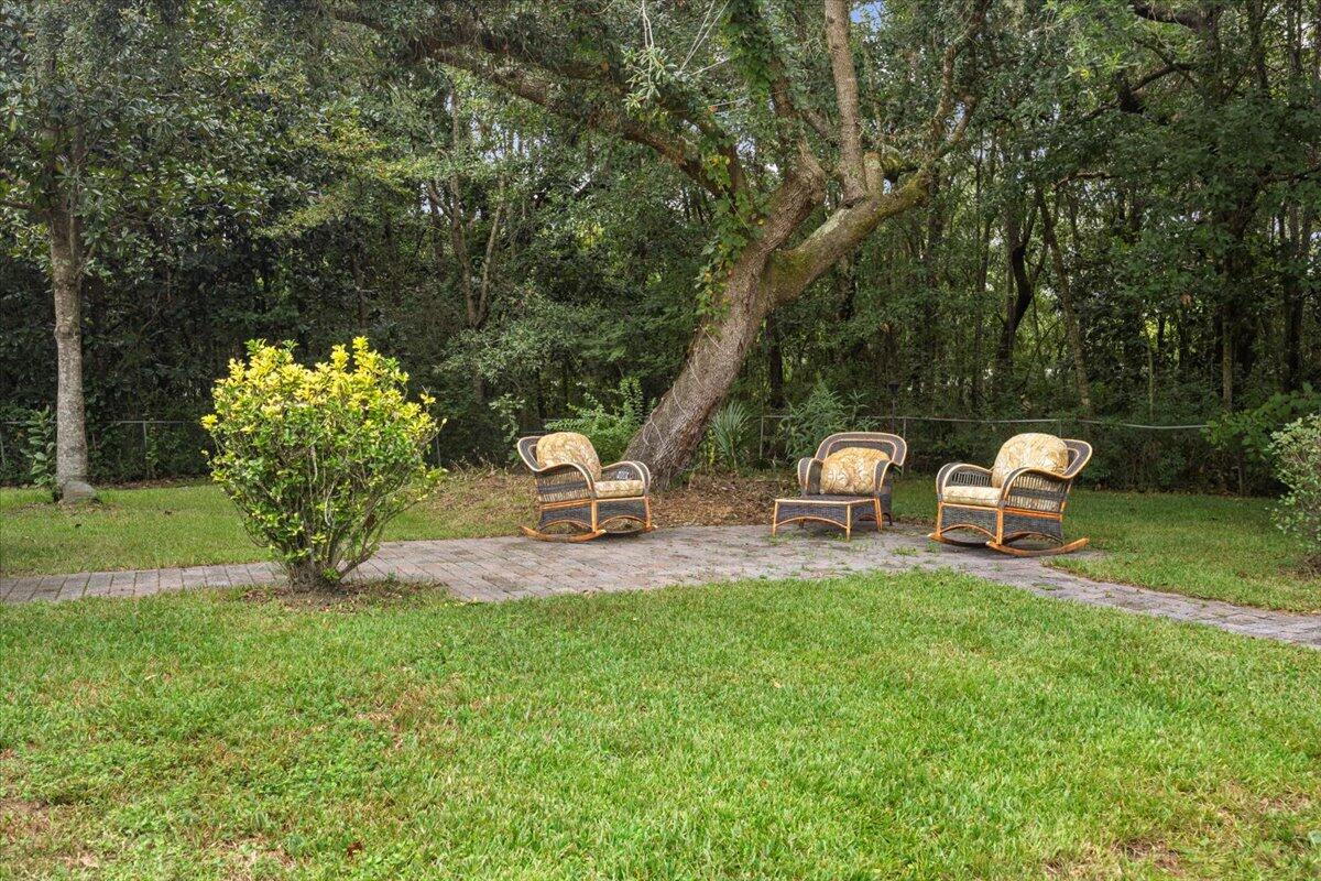 7112 Wells Avenue Navarre, FL 32566 - Photo 40 of 43 a white bench sitting in the grass near a lake