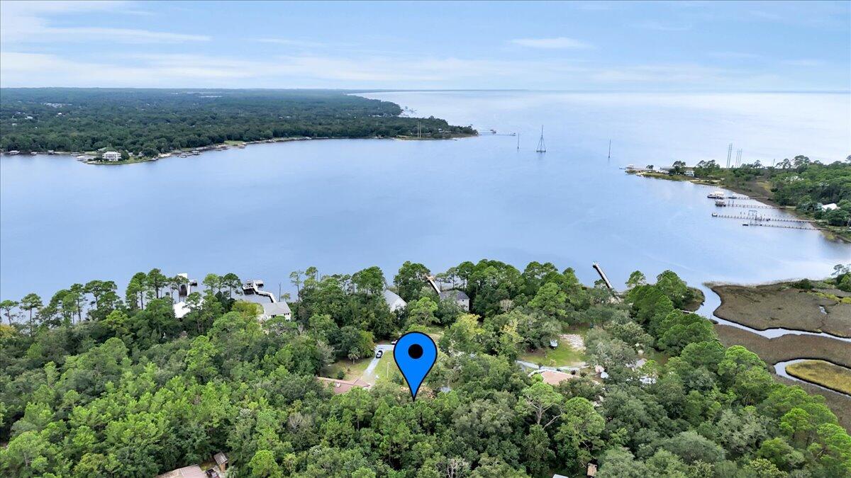 7112 Wells Avenue Navarre, FL 32566 - Photo 41 of 43 an aerial view of a houses with a yard and lake view