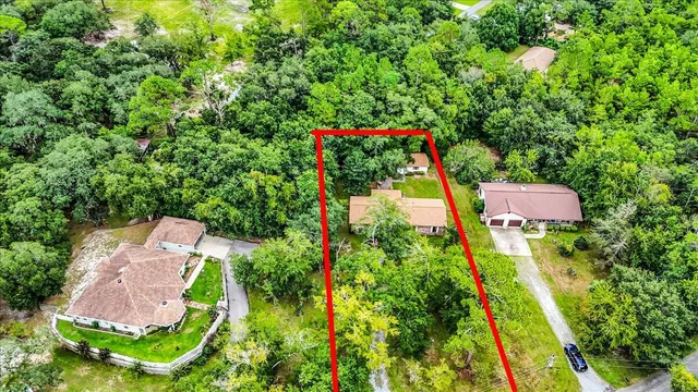 an aerial view of residential house with outdoor space and trees all around