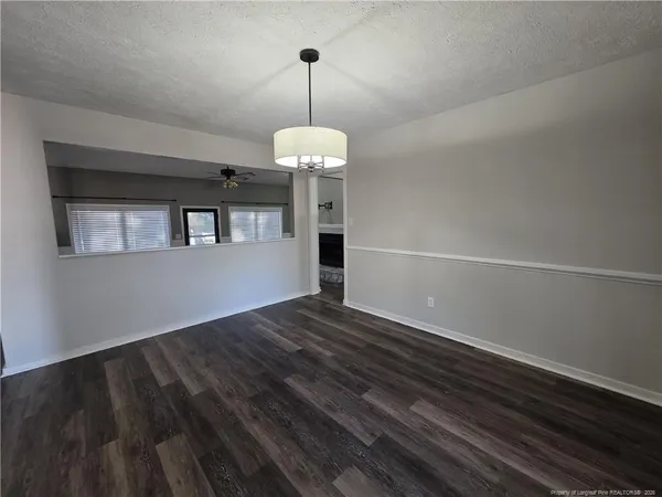 a view of a room with wooden floor chandelier and a window