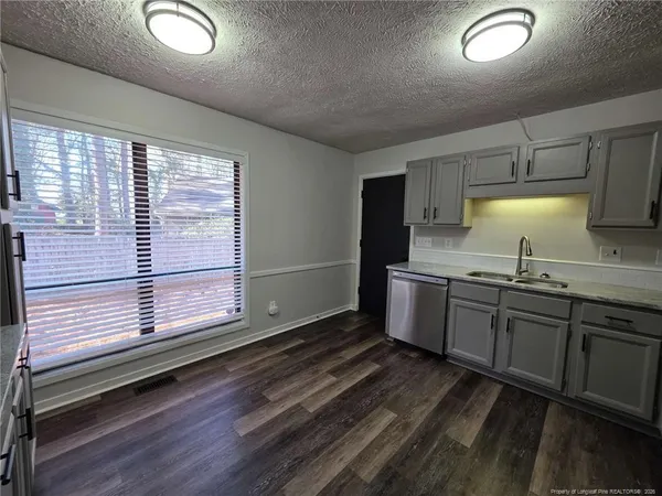 a kitchen with granite countertop a stove a sink and a window