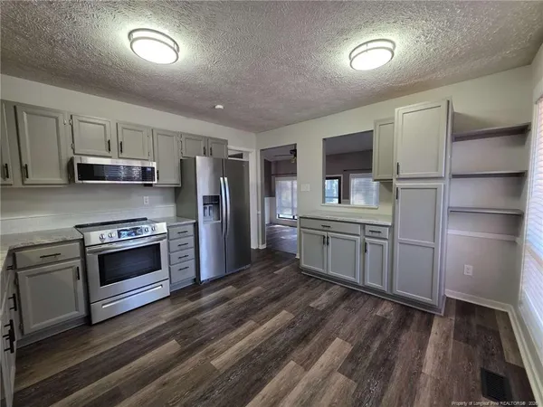 a kitchen with stainless steel appliances a refrigerator and a stove top oven