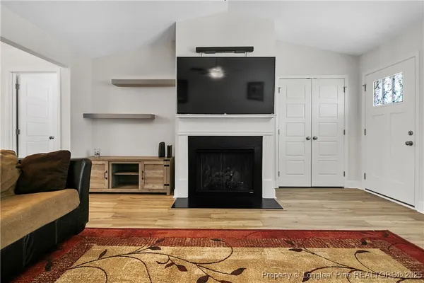 a living room with a fireplace and a flat screen tv