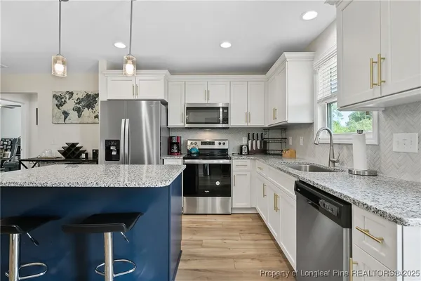 a kitchen with granite countertop kitchen island cabinets and stainless steel appliances
