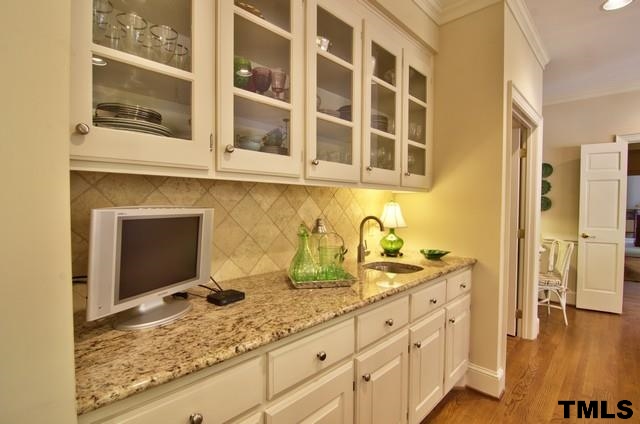 3822 Northampton Road Durham, NC 27707 - Photo 9 of 25 Large center island and this pretty glass front cabinetry are attractive details in this well planned kitchen.