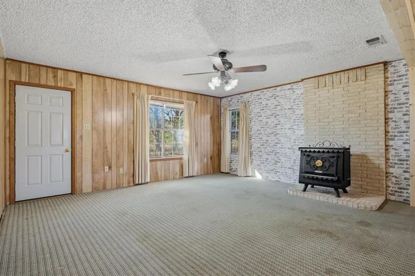 a view of an empty room with window and cabinet