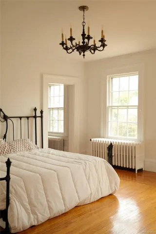 a bedroom with a bed and a chandelier