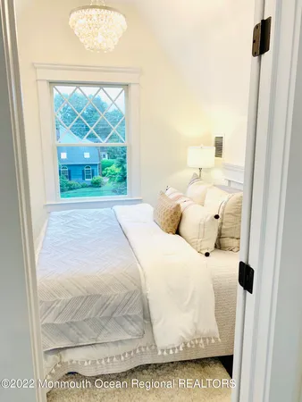 a view of a bedroom with wooden floor and windows