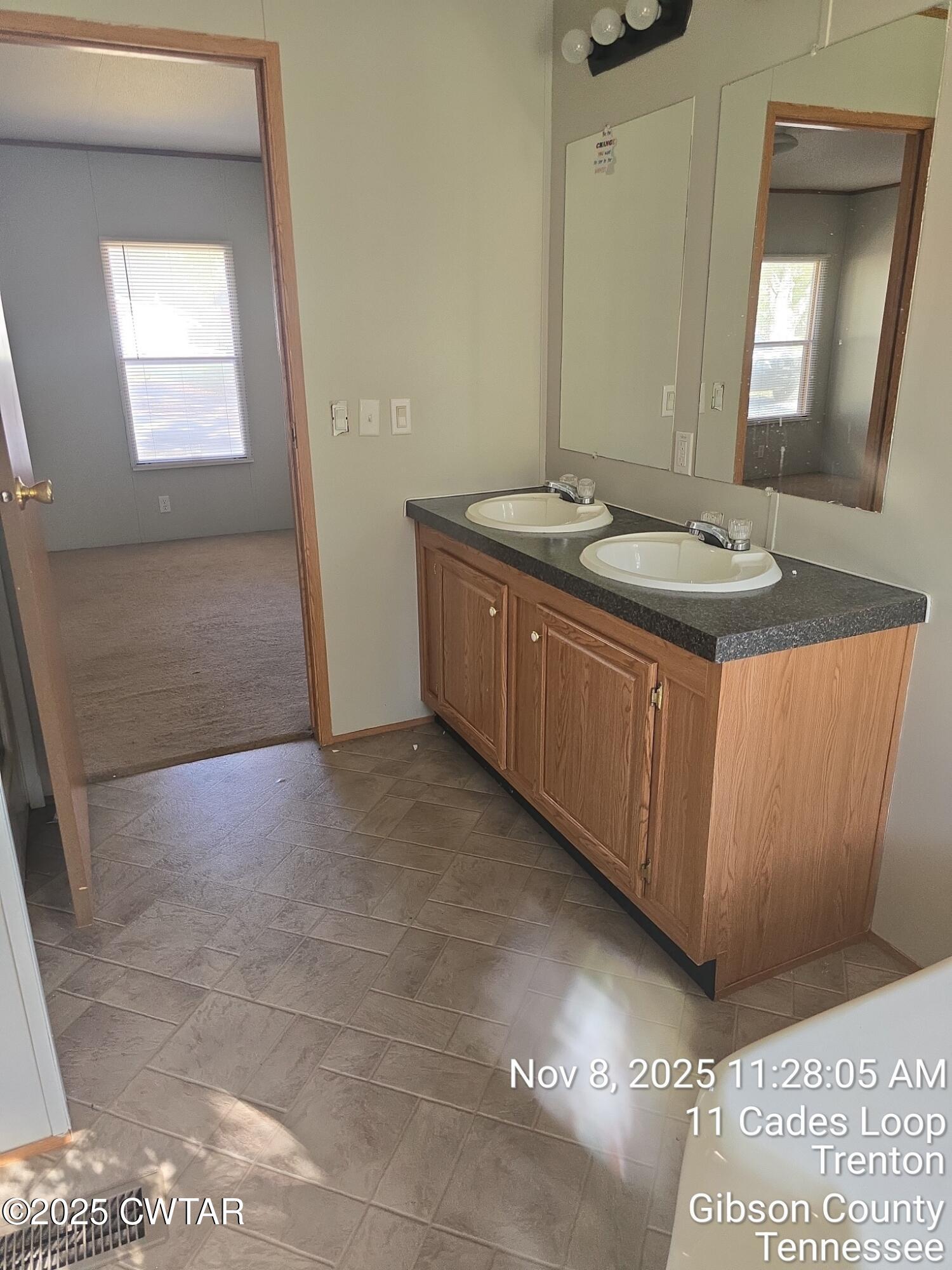 11 Cades Loop Trenton, TN 38382 - Photo 16 of 16 a bathroom with a granite countertop sink a mirror and a vanity