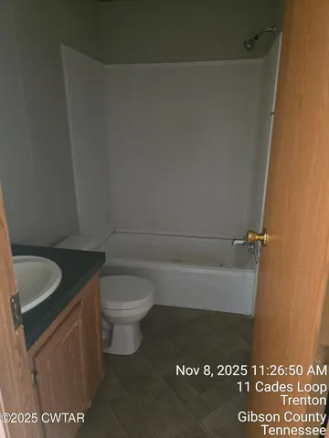 a bathroom with a granite countertop toilet and a sink