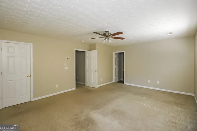 a view of an empty room with a ceiling fan