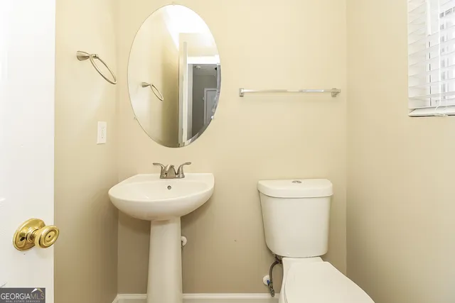 a bathroom with a toilet sink and mirror