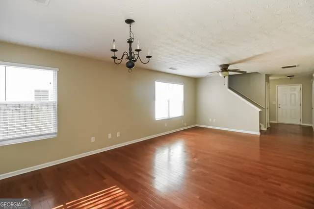 a view of a livingroom with wooden floor and a ceiling fan