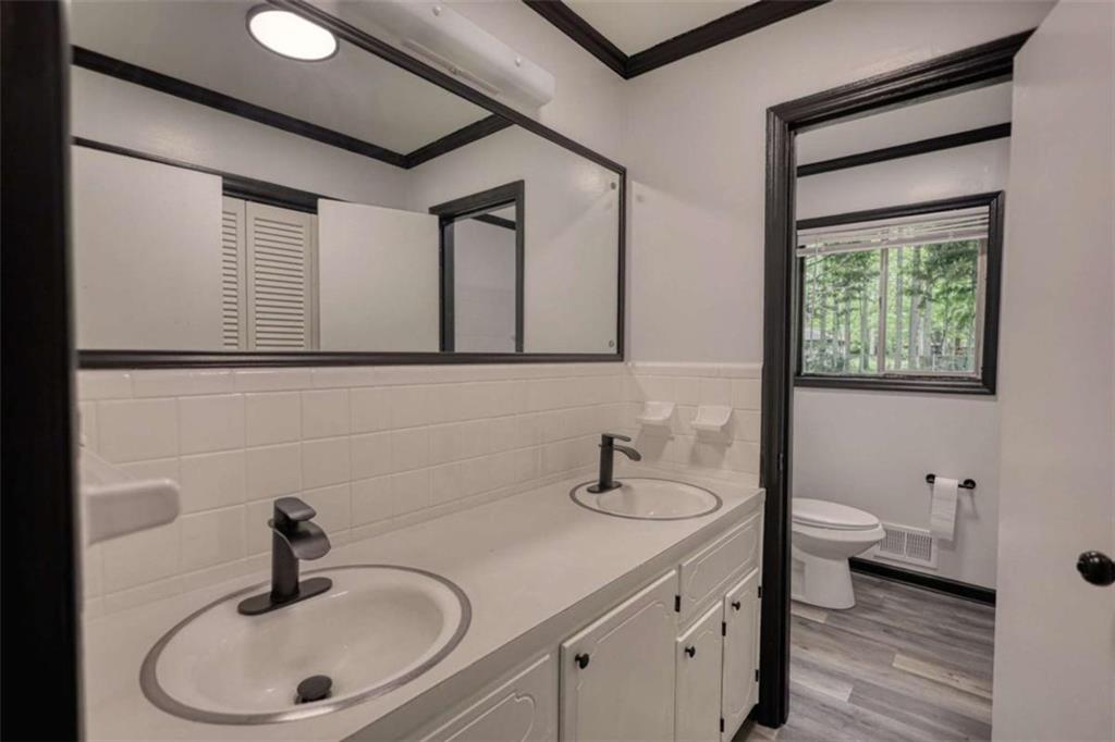 555 Joy Street Jackson, GA 30233 - Photo 32 of 56 a bathroom with a toilet sink a mirror and vanity