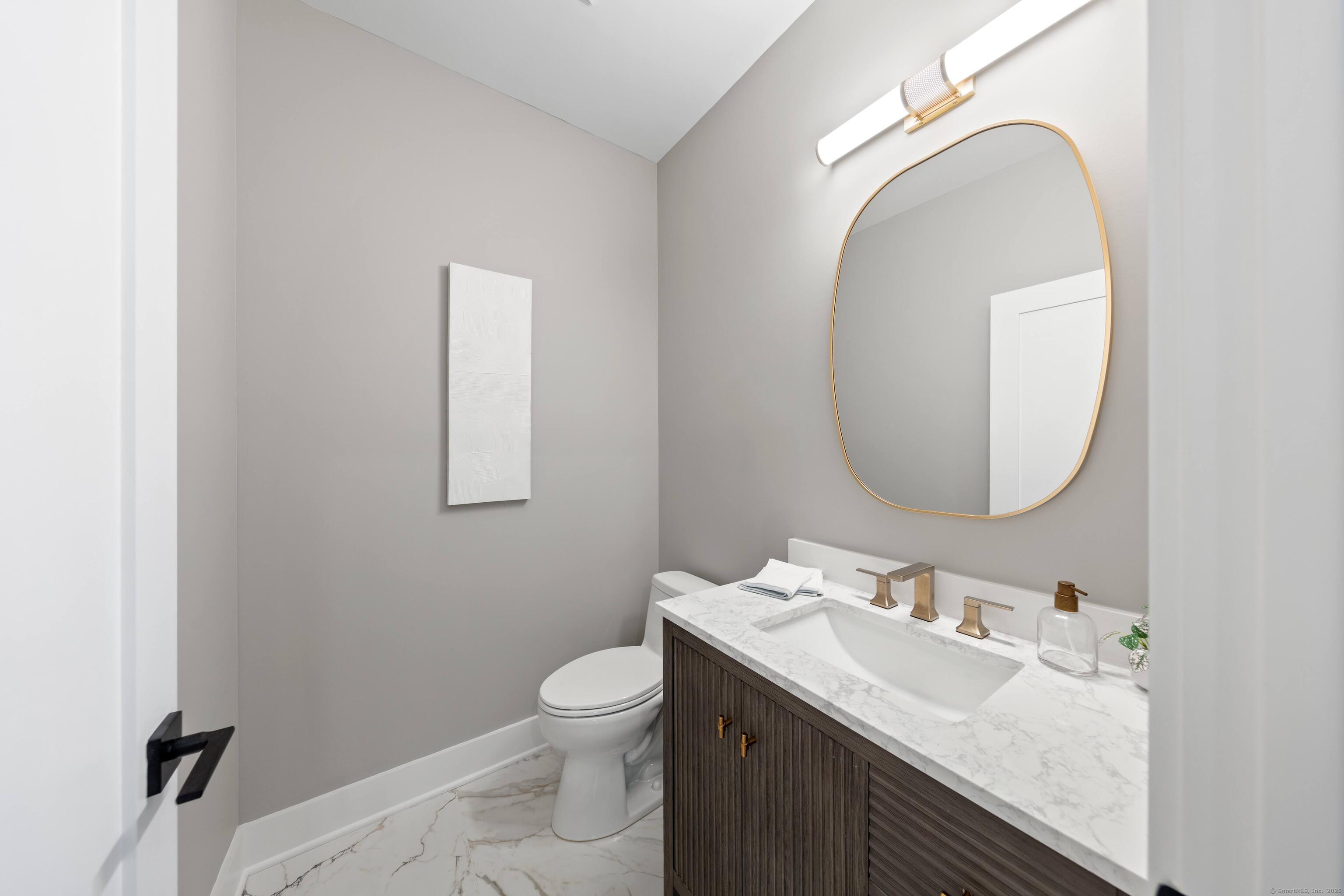 31 Gray Farms Road Stamford, CT 06905 - Photo 18 of 40 a bathroom with a granite countertop toilet a sink and mirror