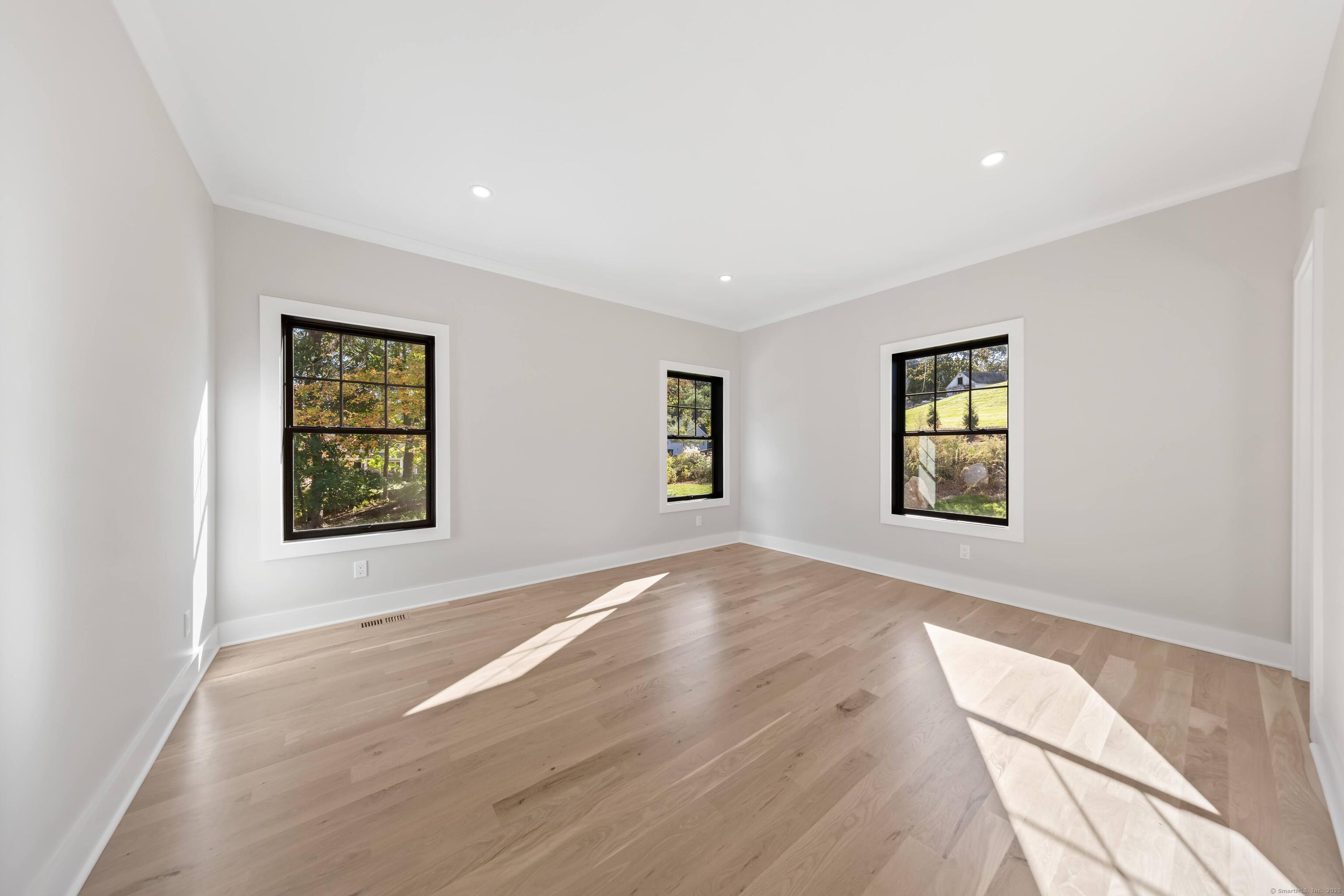 31 Gray Farms Road Stamford, CT 06905 - Photo 19 of 40 a view of an empty room with a window and wooden floor