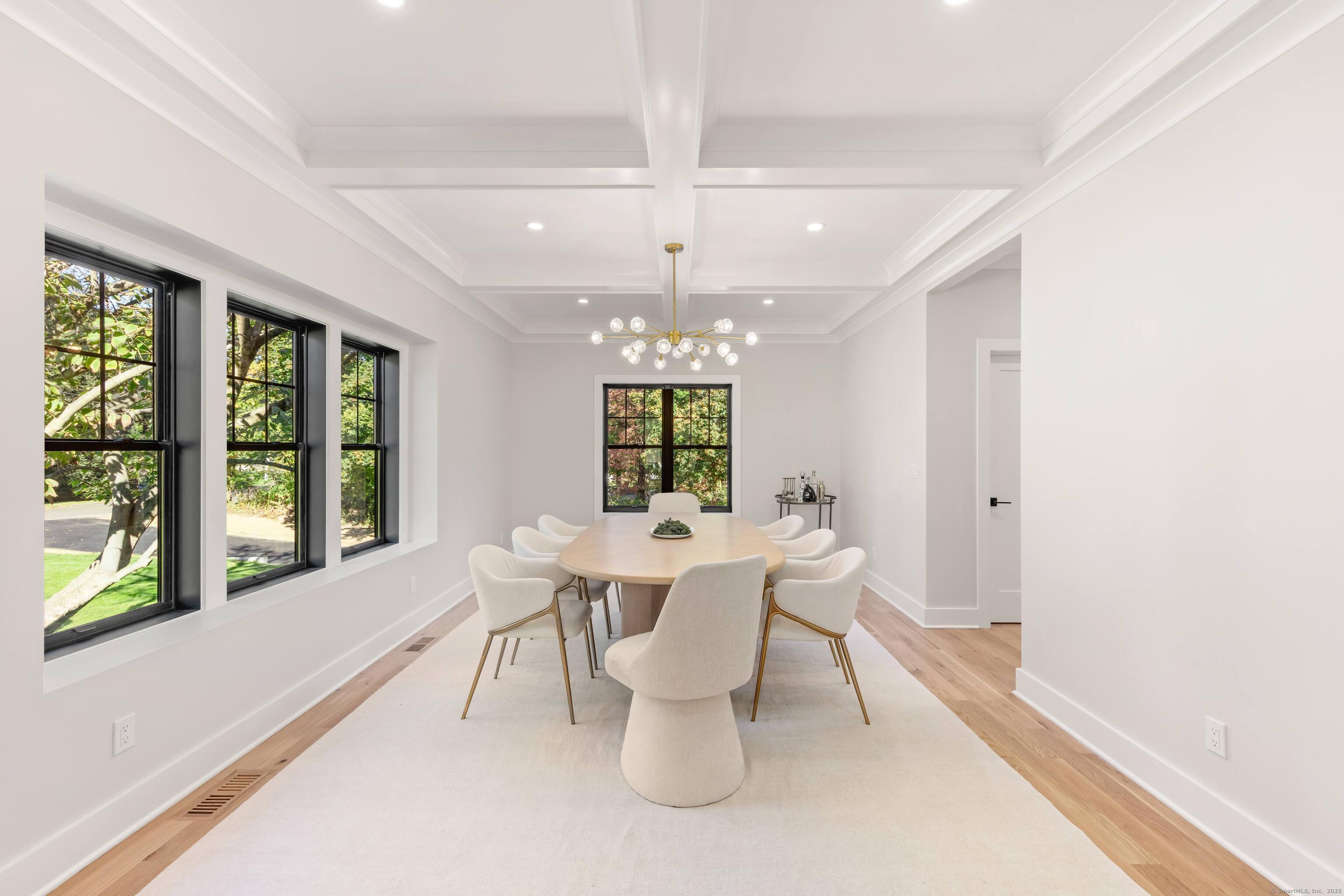 31 Gray Farms Road Stamford, CT 06905 - Photo 8 of 40 a dining room with wooden floor a chandelier a wooden table and chairs
