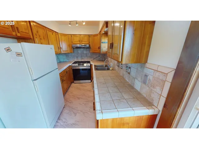 a open kitchen with a sink and a refrigerator