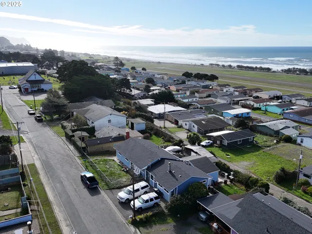 an aerial view of a city with lots of residential buildings and mountain view in back