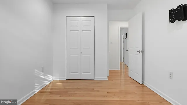 a view of a livingroom with an entryway and wooden floor