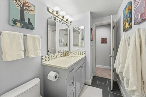 a bathroom with a sink a mirror a toilet and a shower curtain