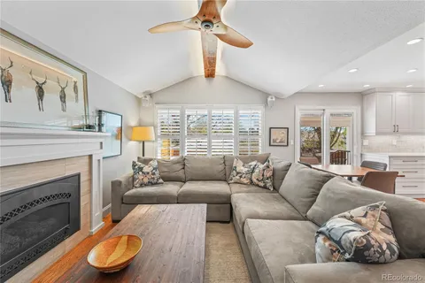 a living room with furniture a fireplace and a large window