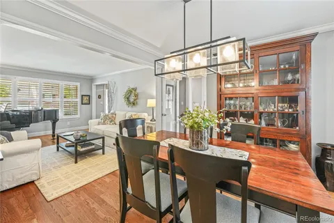 a dining room with furniture a chandelier and wooden floor
