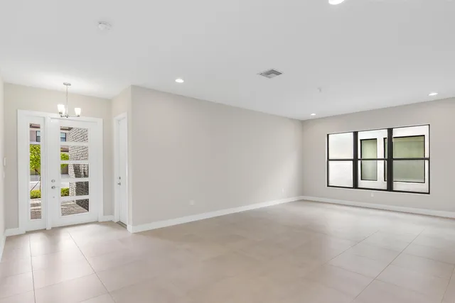 a view of an empty room with a window and cabinet