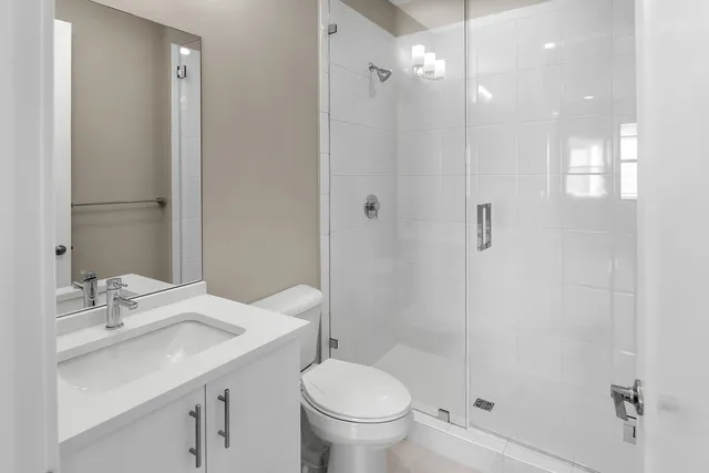 a bathroom with a sink a toilet and shower