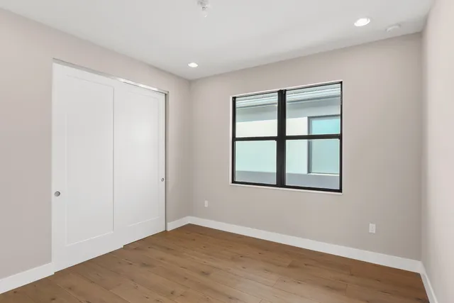 an empty room with wooden floor and windows