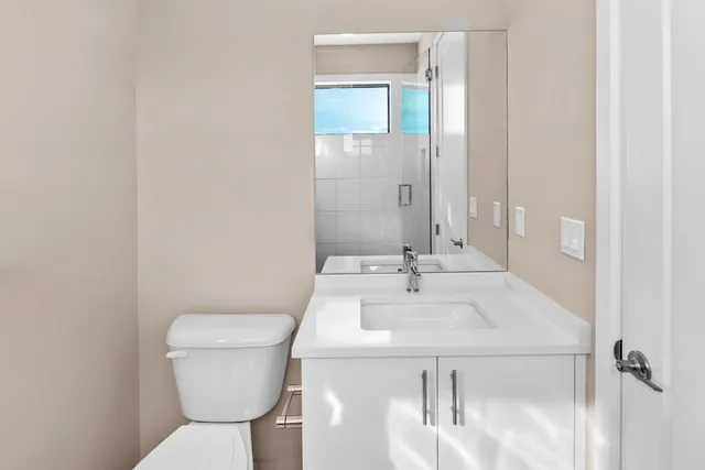 a bathroom with a toilet sink and mirror
