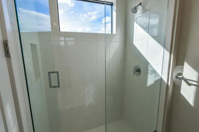 a bathroom with a glass shower door and a mirror