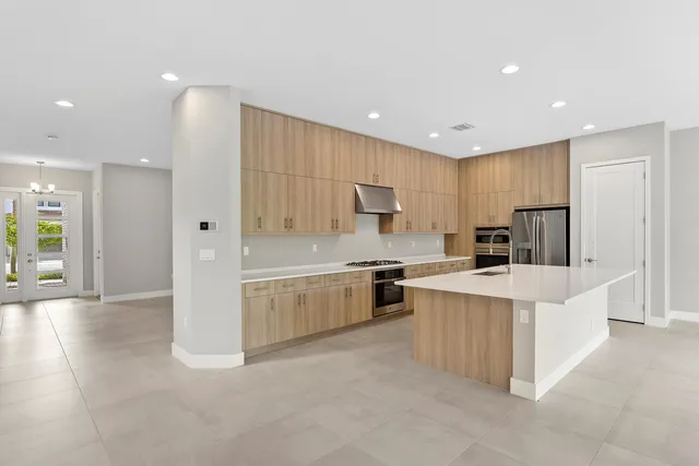 a large white kitchen with stainless steel appliances