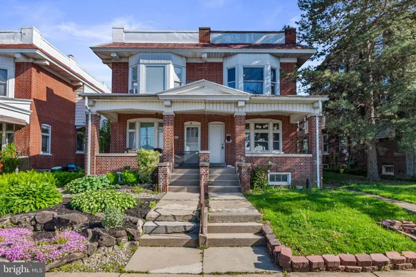 front view of a brick house with a yard