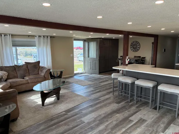a living room with furniture a wooden floor and chandelier