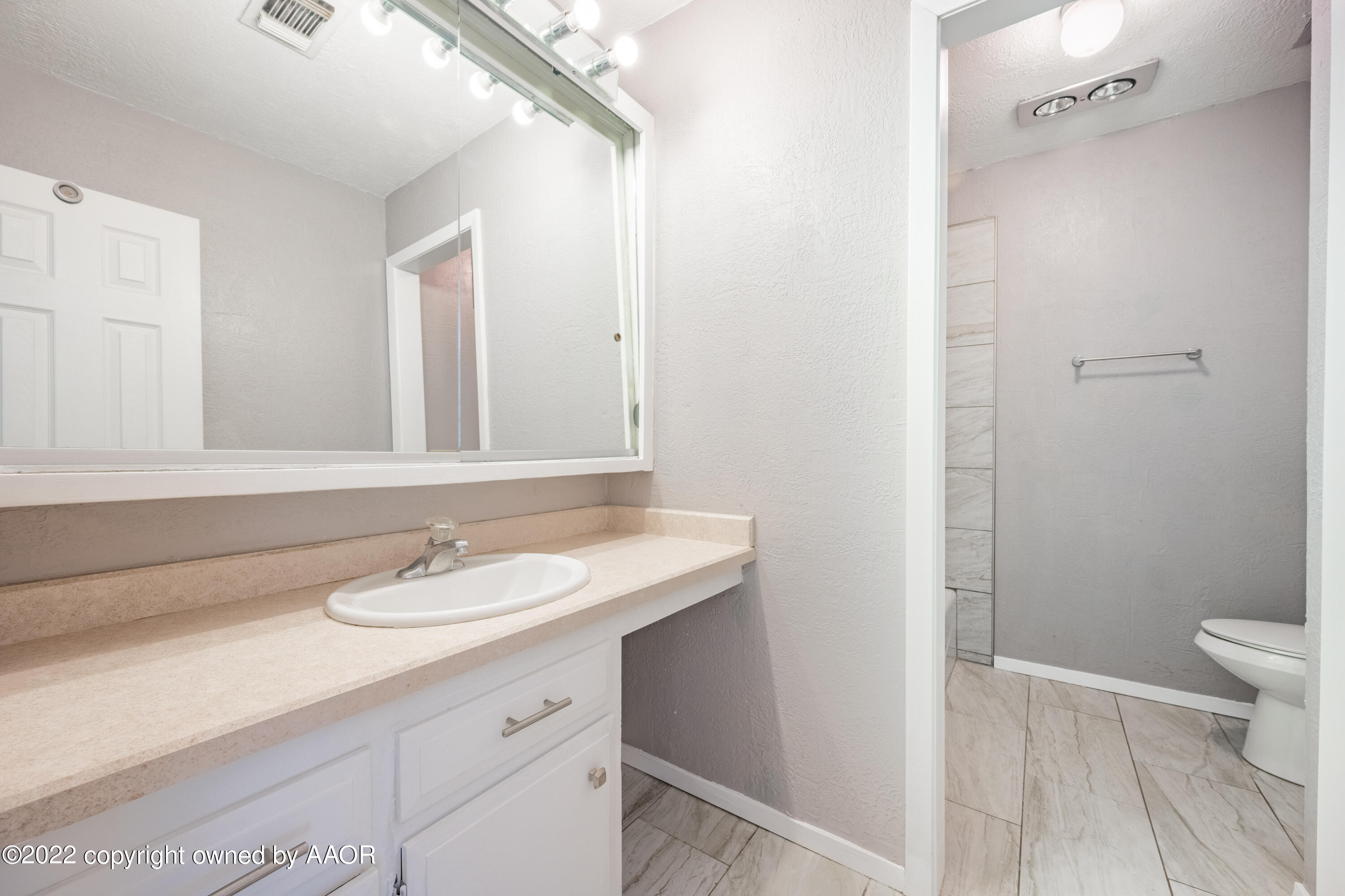 4610 South Georgia Street Amarillo, TX 79110 - Photo 11 of 25 a bathroom with a sink a toilet and a mirror