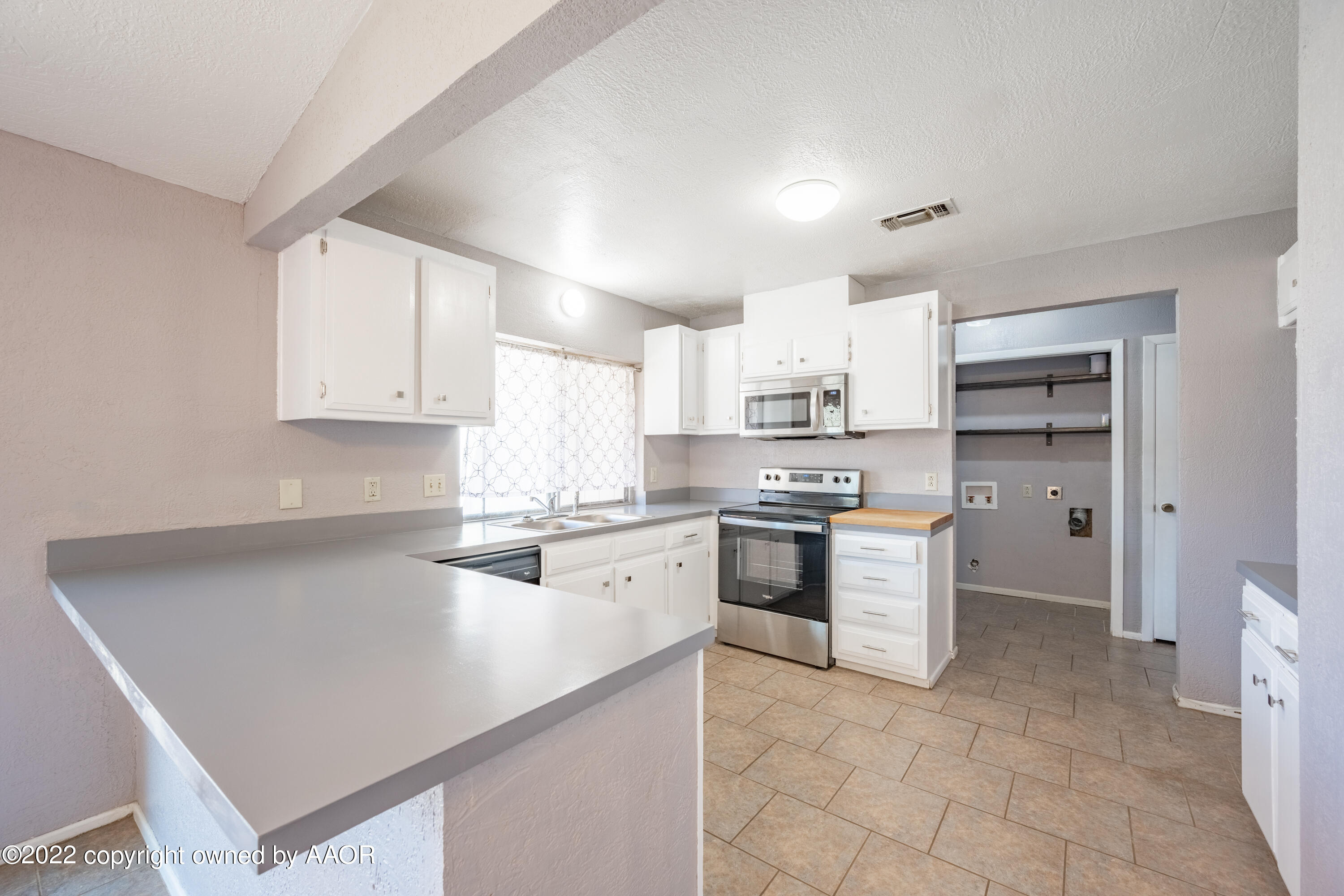 4610 South Georgia Street Amarillo, TX 79110 - Photo 6 of 25 a kitchen with a sink a stove top oven and cabinets