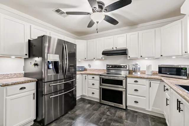 a kitchen with cabinets a sink dishwasher a dining table and chairs with wooden floor