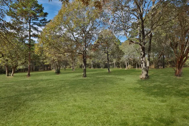 a view of a house with a big yard and sitting area
