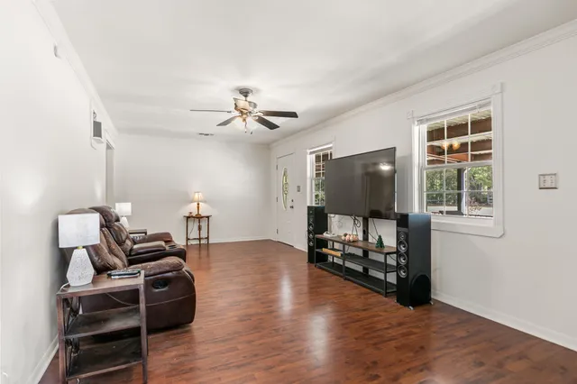 a kitchen with stainless steel appliances a dining table chairs refrigerator sink and cabinets