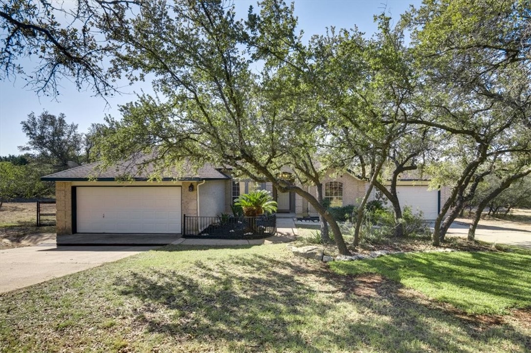a front view of house with yard and trees around