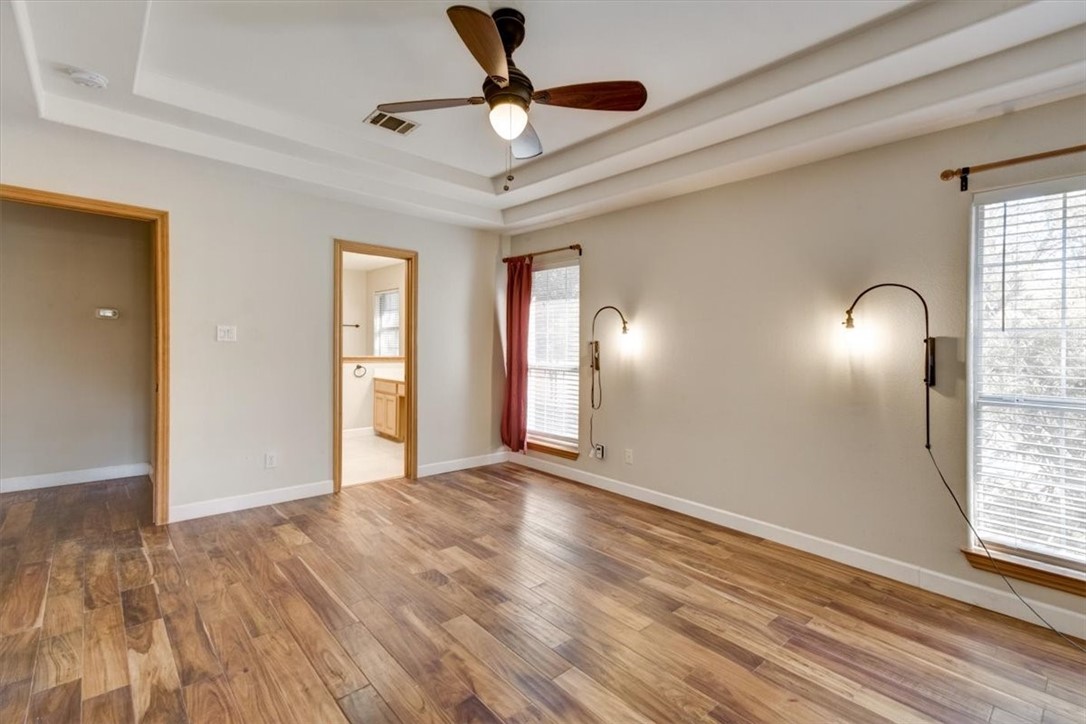 21415 Boggy Ford Road Lago Vista, TX 78645 - Photo 17 of 40 a view of an empty room with window and wooden floor