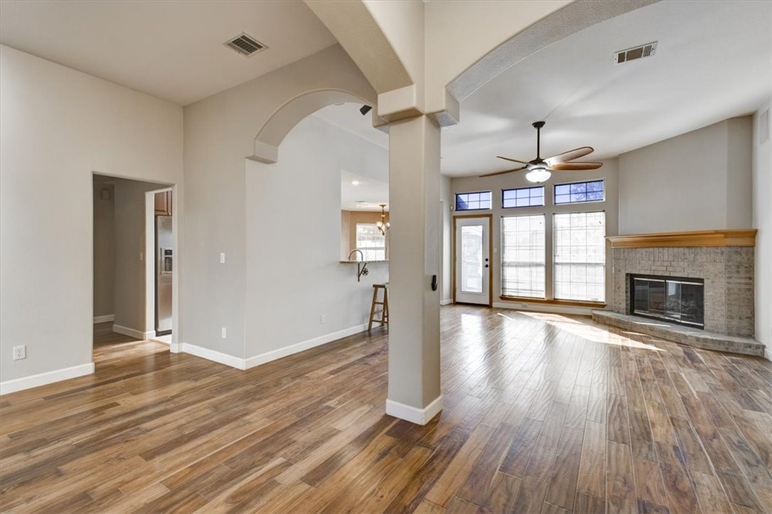 21415 Boggy Ford Road Lago Vista, TX 78645 - Photo 4 of 40 an empty room with wooden floor and fireplace