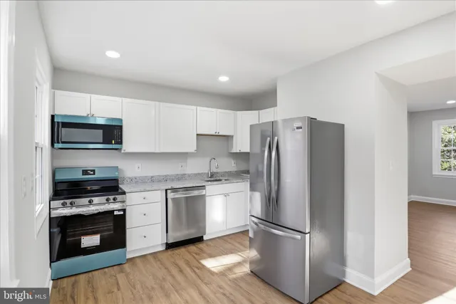 a kitchen with stainless steel appliances granite countertop a refrigerator stove and sink
