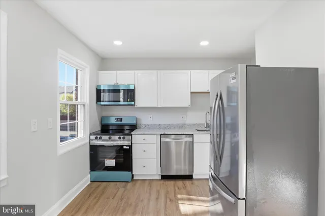 a kitchen with stainless steel appliances a refrigerator stove and microwave