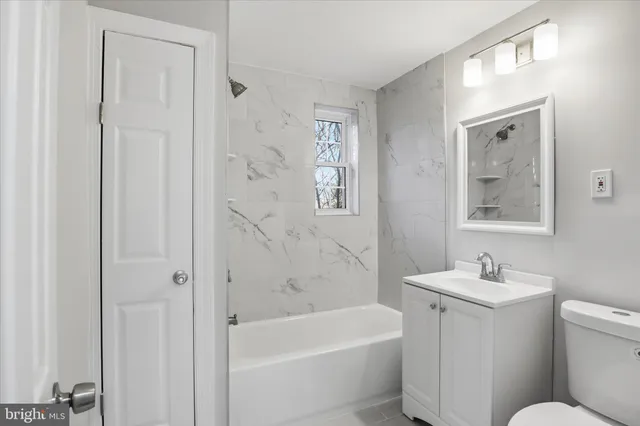 a bath room with a toilet a sink and a bath tub